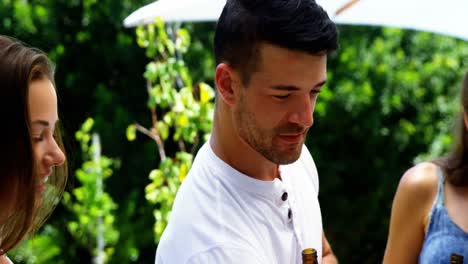 Group-of-friends-having-a-bottle-of-beer-near-poolside