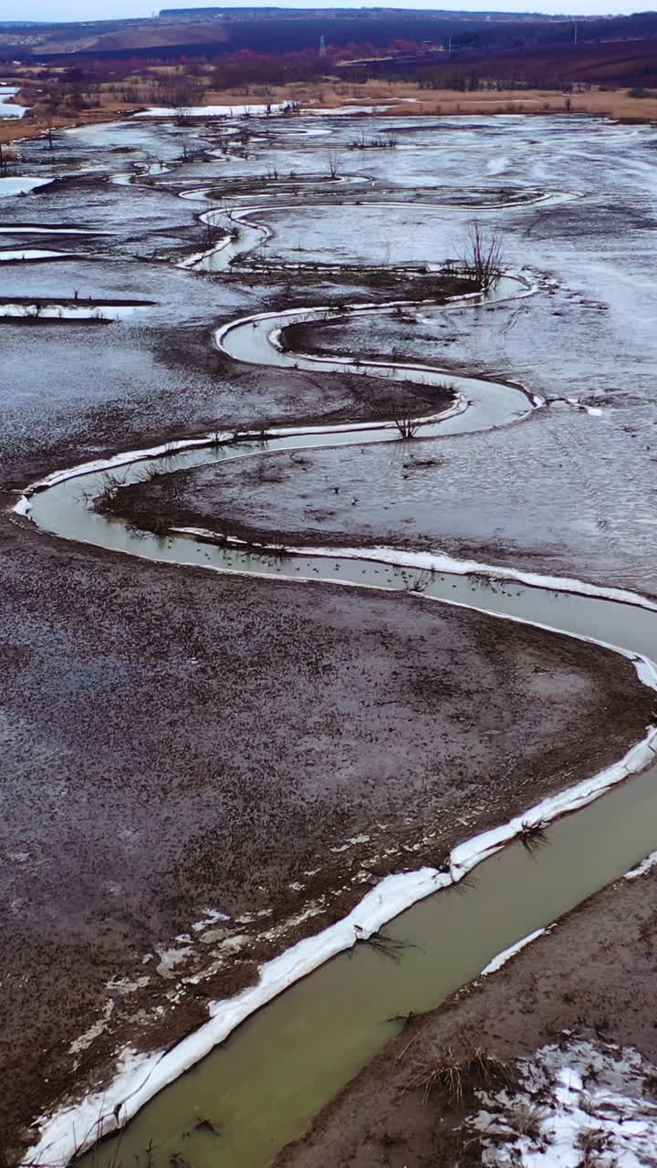 Dried lake. Ecological disaster in environment. Global warming. Tortuous river on dirty background. Motion camera back. Aerial view. Vertical video