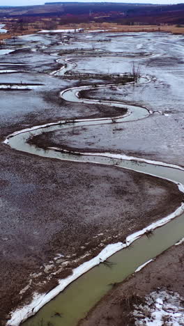 dried lake. ecological disaster in environment. global warming. tortuous river on dirty background. motion camera back. aerial view. vertical video