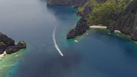 a speedboat motors into an island lagoon in the philippines