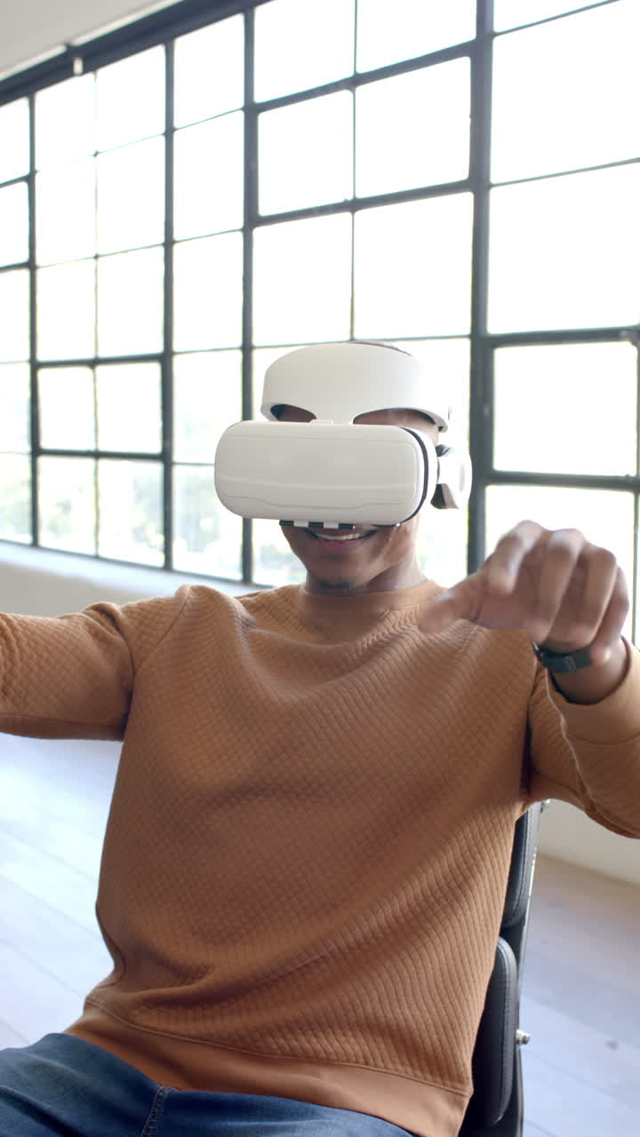 Vertical video: Using VR headset, man sitting and experiencing virtual reality in office