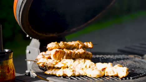 Close-up-footage-of-chicken-barbecue-being-stacked-on-top-of-each-other-and-the-grill-being-cleaned-by-a-man-at-the-same-time