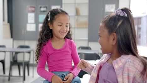 in school, two girls smiling and talking in classroom, enjoying time together