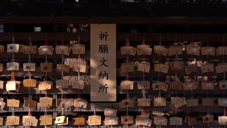 Dolly-in-towards-wall-of-wishing-cards-at-Japanese-Shrine