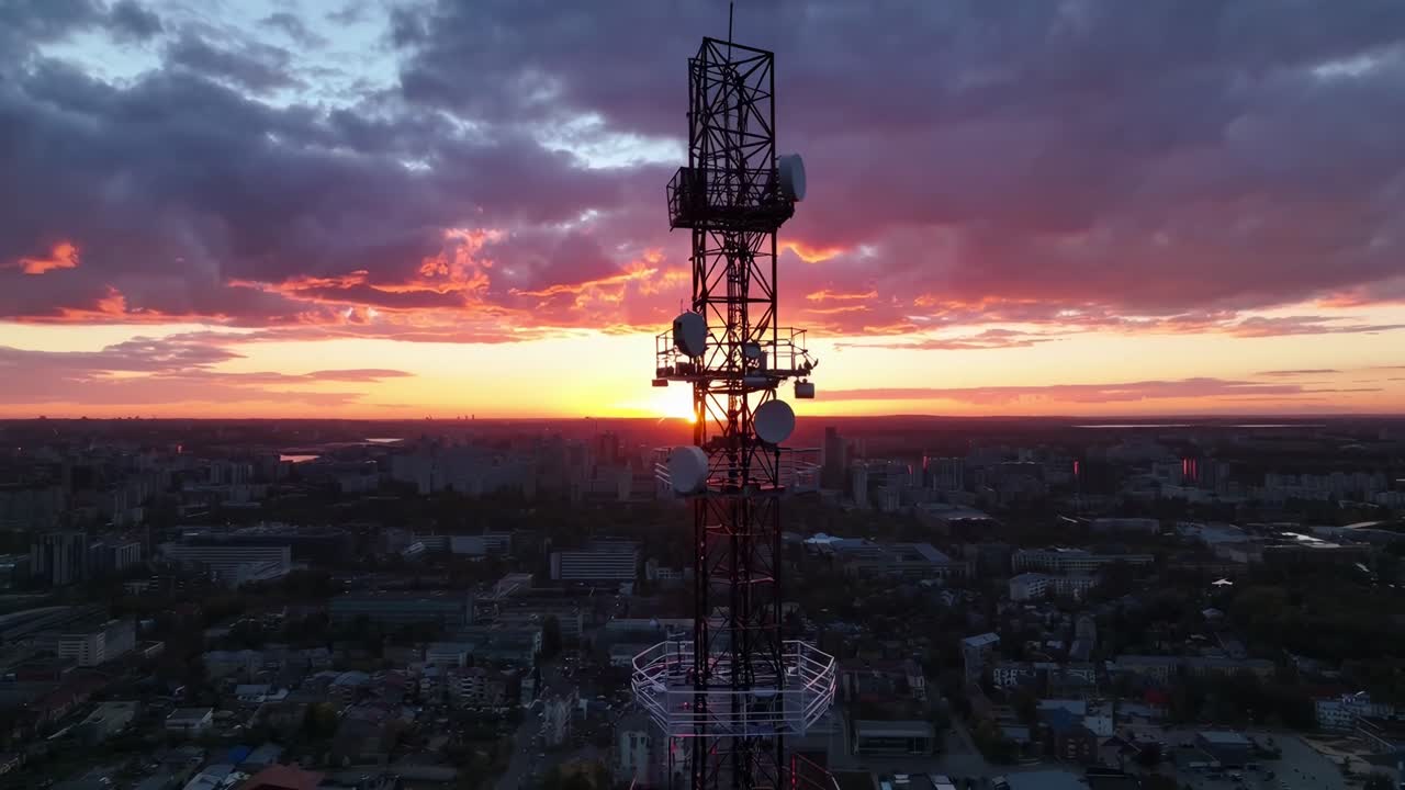 Prise de vue vidéo aérienne d'une tour de communication au coucher du soleil, capturant un horizon spectaculaire