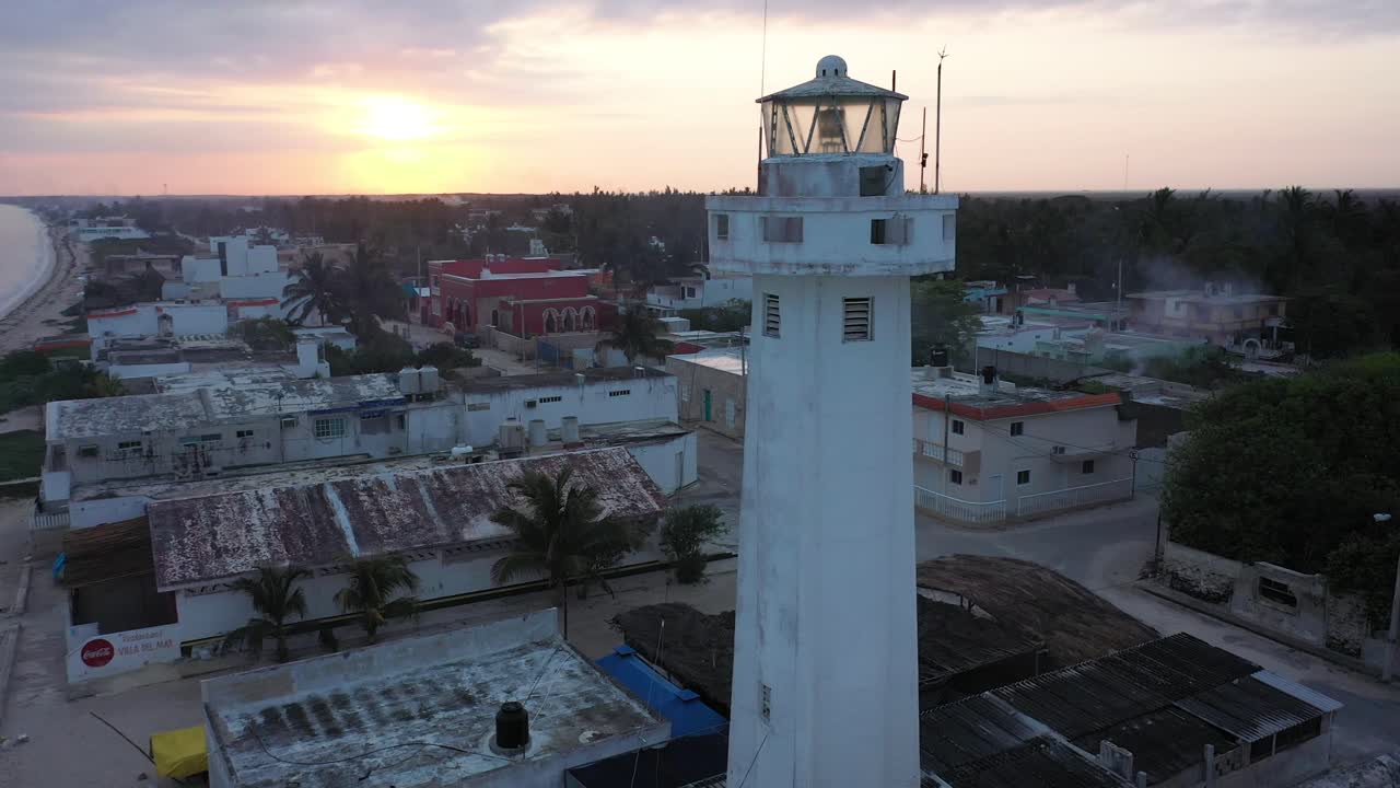 toma aérea de camiones a la derecha al amanecer con el cierre del faro en telchac puerto en yucatán, méxico