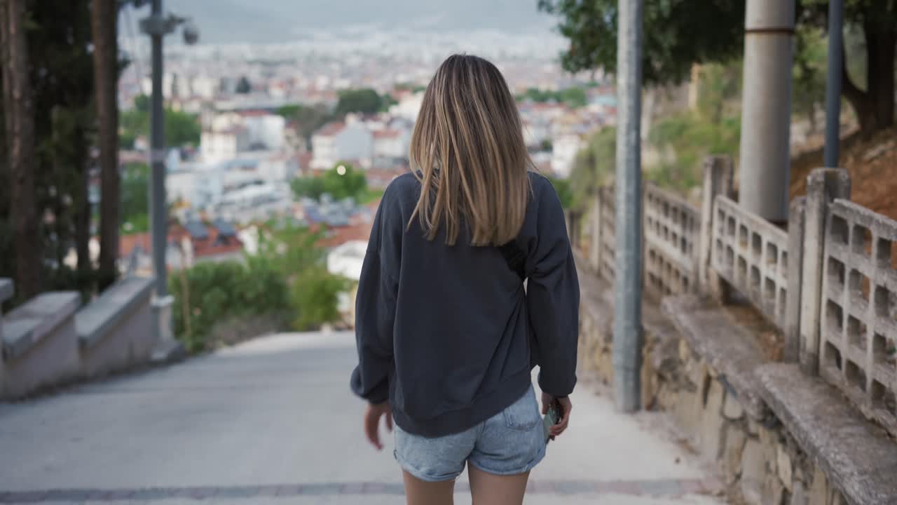 Blonde young female traveler sightseeing and enjoying summer vacation in an old traditional costal town