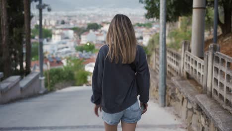 blonde young female traveler sightseeing and enjoying summer vacation in an old traditional costal town