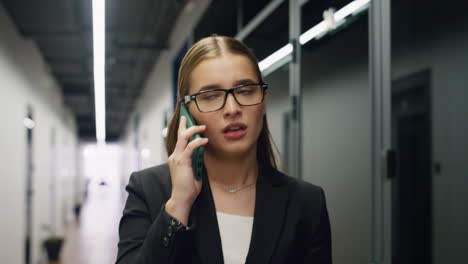 Office-manager-talking-phone-walking-contemporary-business-center-portrait.