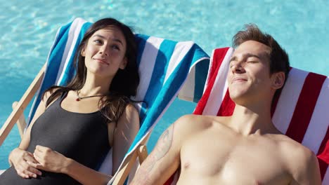 contented young couple smiling as they sunbathe