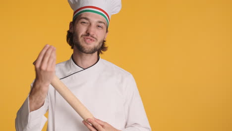 caucasian chef in front of camera on yellow background.