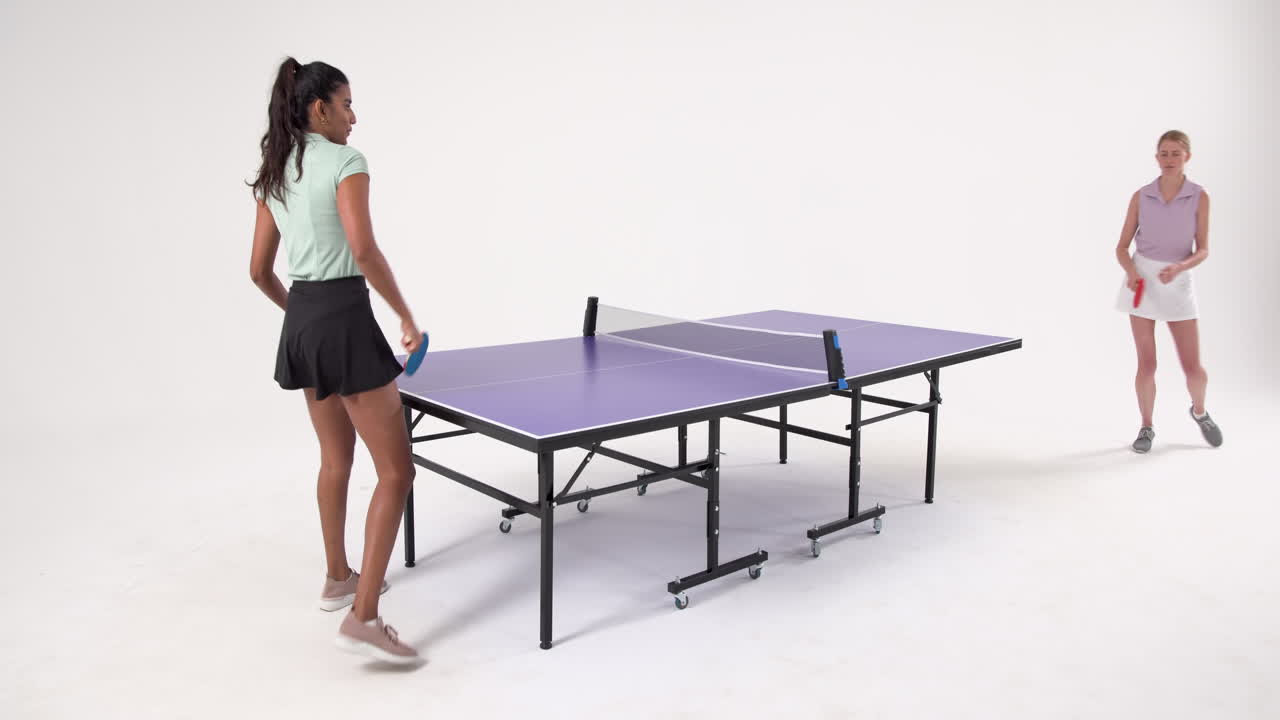 Playing table tennis, woman holding paddle and standing next to table