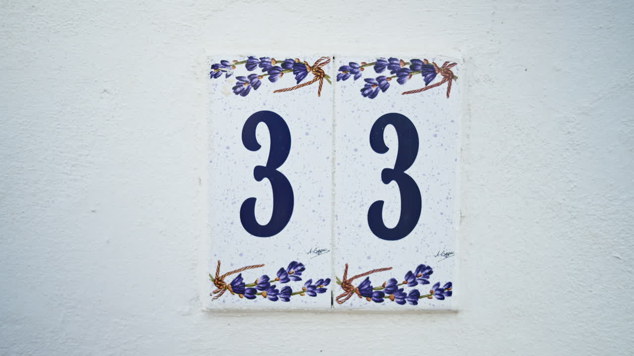 Close up of the number 33 on a white house