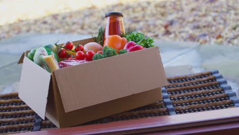 caja de ingredientes frescos para kit de recetas de comidas en línea entregado a casa en la puerta - filmado en cámara lenta