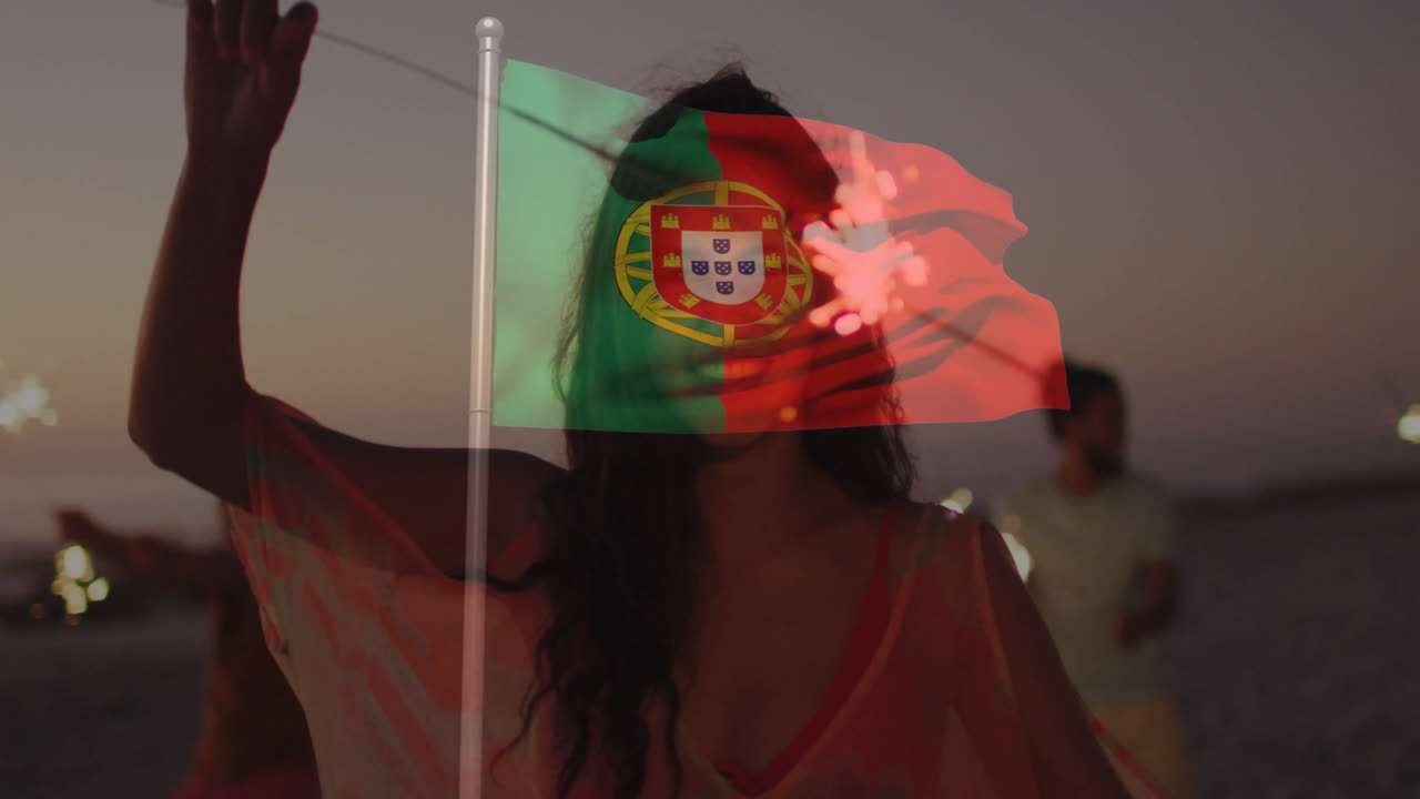 Celebrating at beach, woman holding Portugal flag overlay and sparklers animation