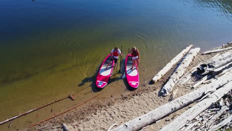 pareja aparcando paddleboard en la orilla del río en un día soleado 4k