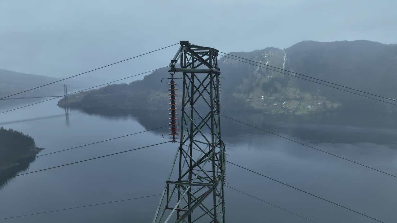 A high voltage mast in Bergen, Norway, rotates with a parallax effect against the fjord and mountains. Osteroy Bridge and road E16 are revealed at the end