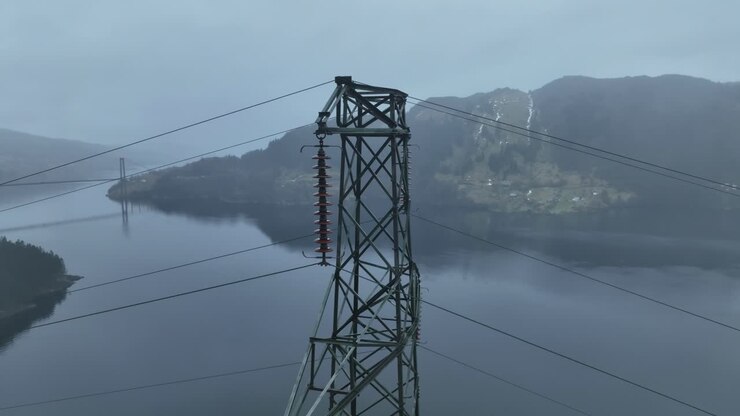 A high voltage mast in Bergen, Norway, rotates with a parallax effect against the fjord and mountains. Osteroy Bridge and road E16 are revealed at the end