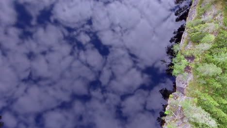 imágenes de drones surrealistas de un lago forestal de superficie de espejo tranquilo con fascinantes reflejos del cielo