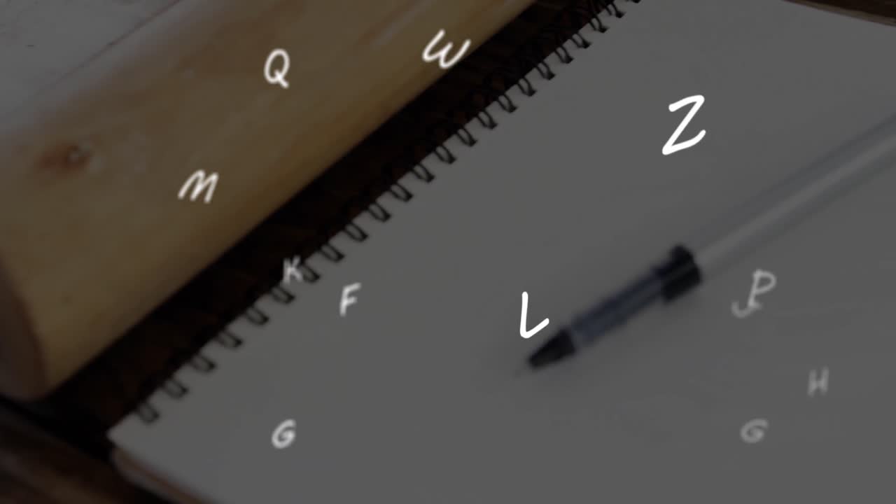 Animation of floating letters over a pen lying on a notebook