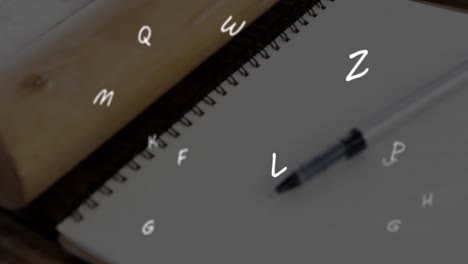 animation of floating letters over a pen lying on a notebook