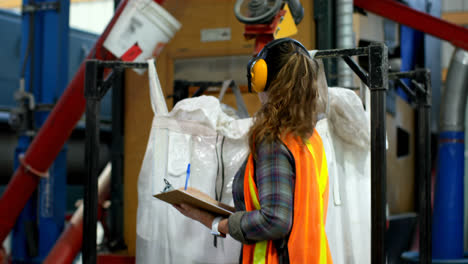 Seitenansicht-Einer-Jungen-Kaukasischen-Arbeiterin,-Die-Lagerbestände-In-Der-Fabrik-überprüft-4k