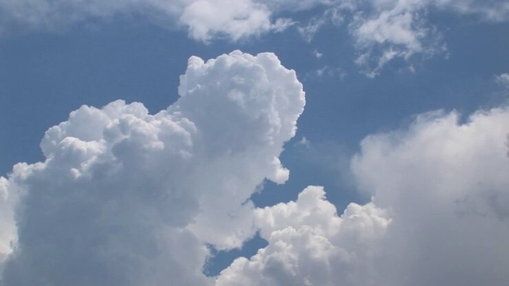 A time lapse of thunderclouds expanding in a blue sky
