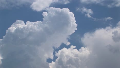 a time lapse of thunderclouds expanding in a blue sky