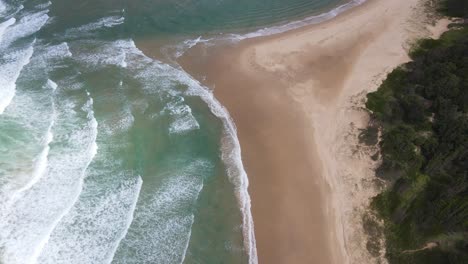 White-Waves-Rolling-Onto-Shore-With-Lush-Vegetation-At-Sawtell-Beach-In-New-South-Wales,-Australia