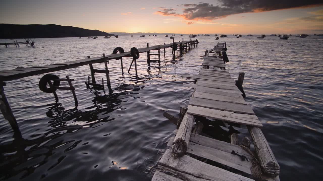 Sunset view, over a wooden pier, of Lake Titicaca, from Copacabana town, Bolivia
