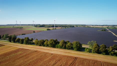 Renewable-energy-production-grid-with-solar-panels-and-wind-turbine,-aerial-view