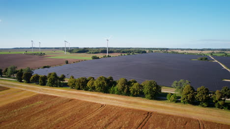 renewable energy production grid with solar panels and wind turbine, aerial view