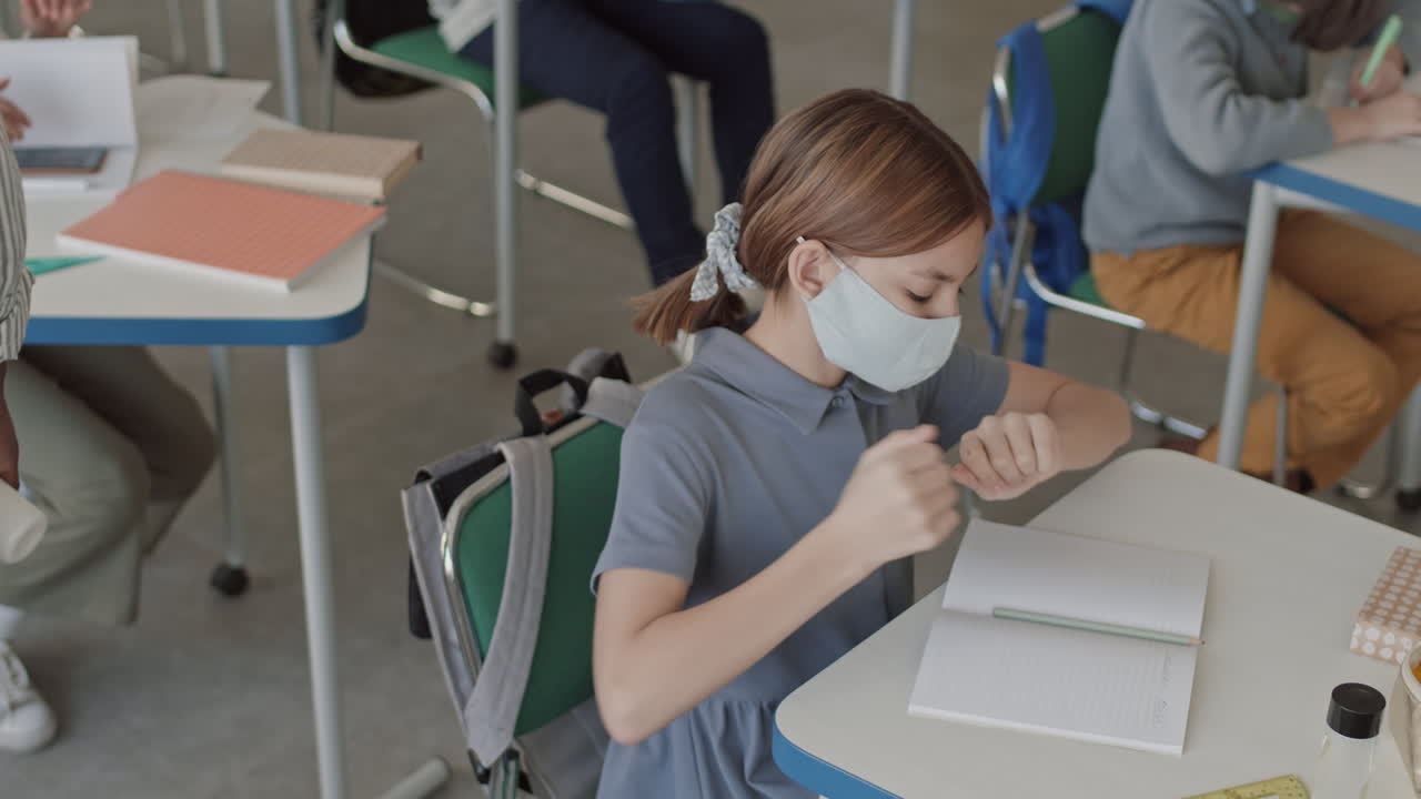 School Girl in Face Mask Using Sanitizer in Classroom