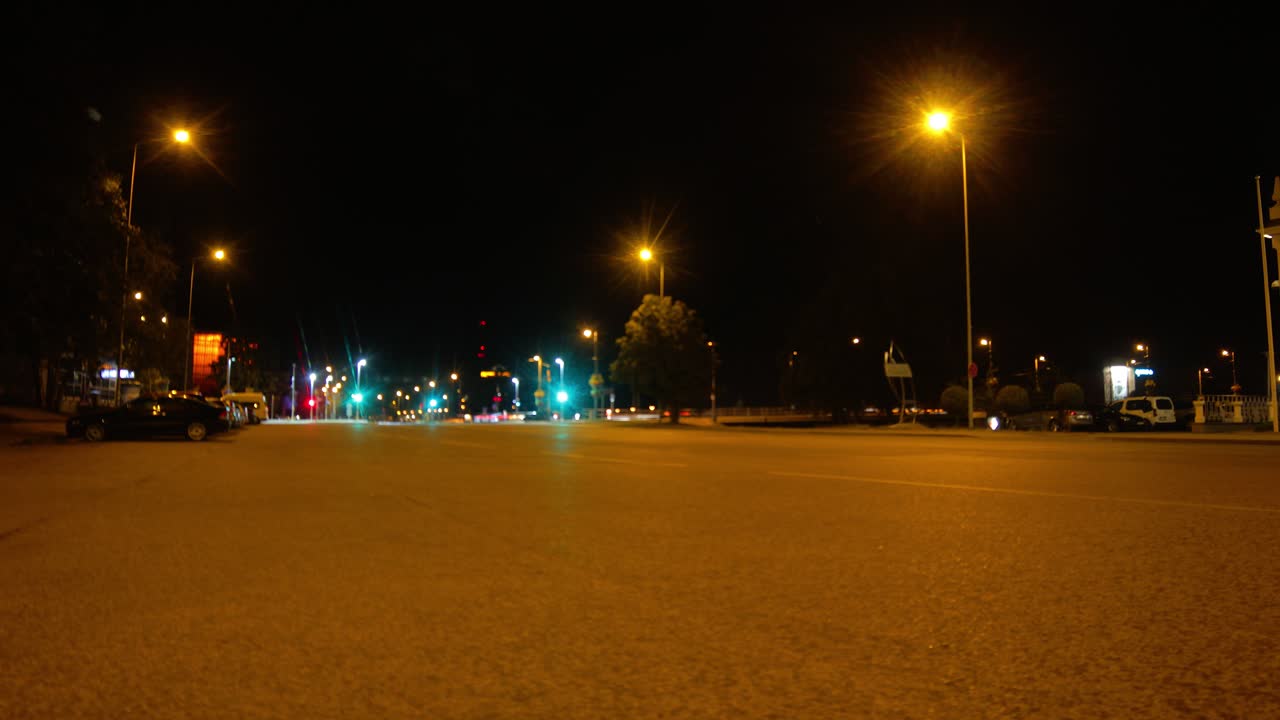 Time lapse di traffico tranquillo di notte nella città di Liepaja, Lettonia, con inquadratura grandangolare dal basso e zoom in.