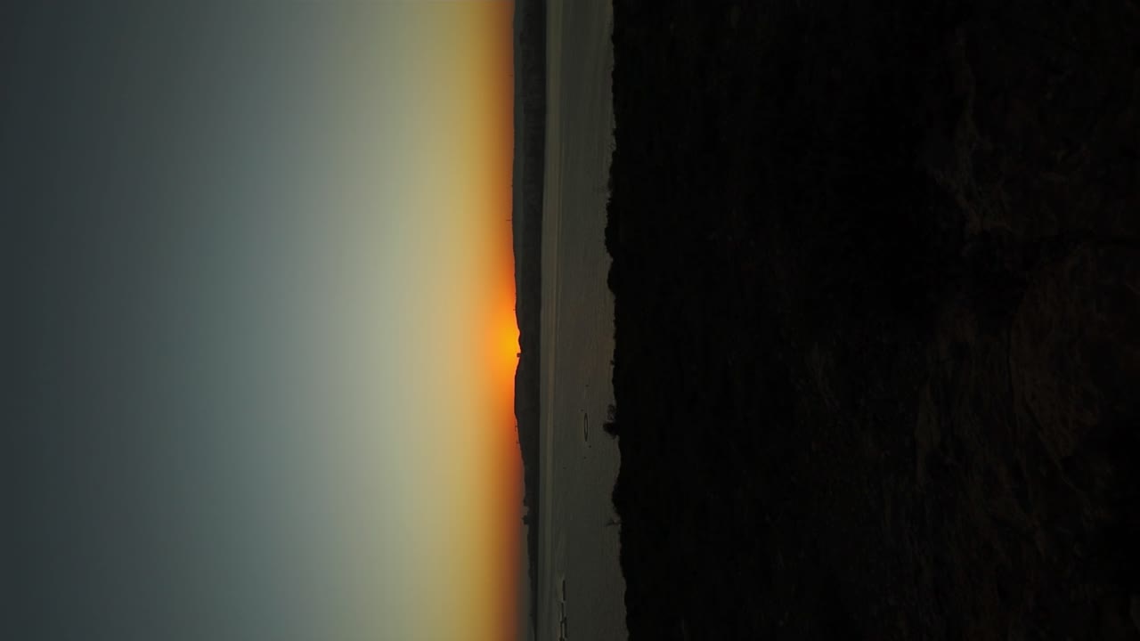 Timelapse of sunrise at the coast of Selmun Bay in Malta - vertical