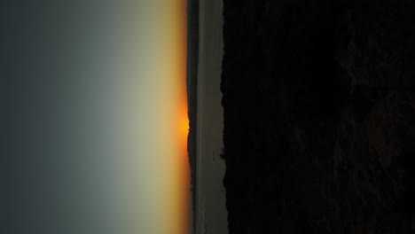 timelapse del amanecer en la costa de la bahía de selmun en malta - vertical