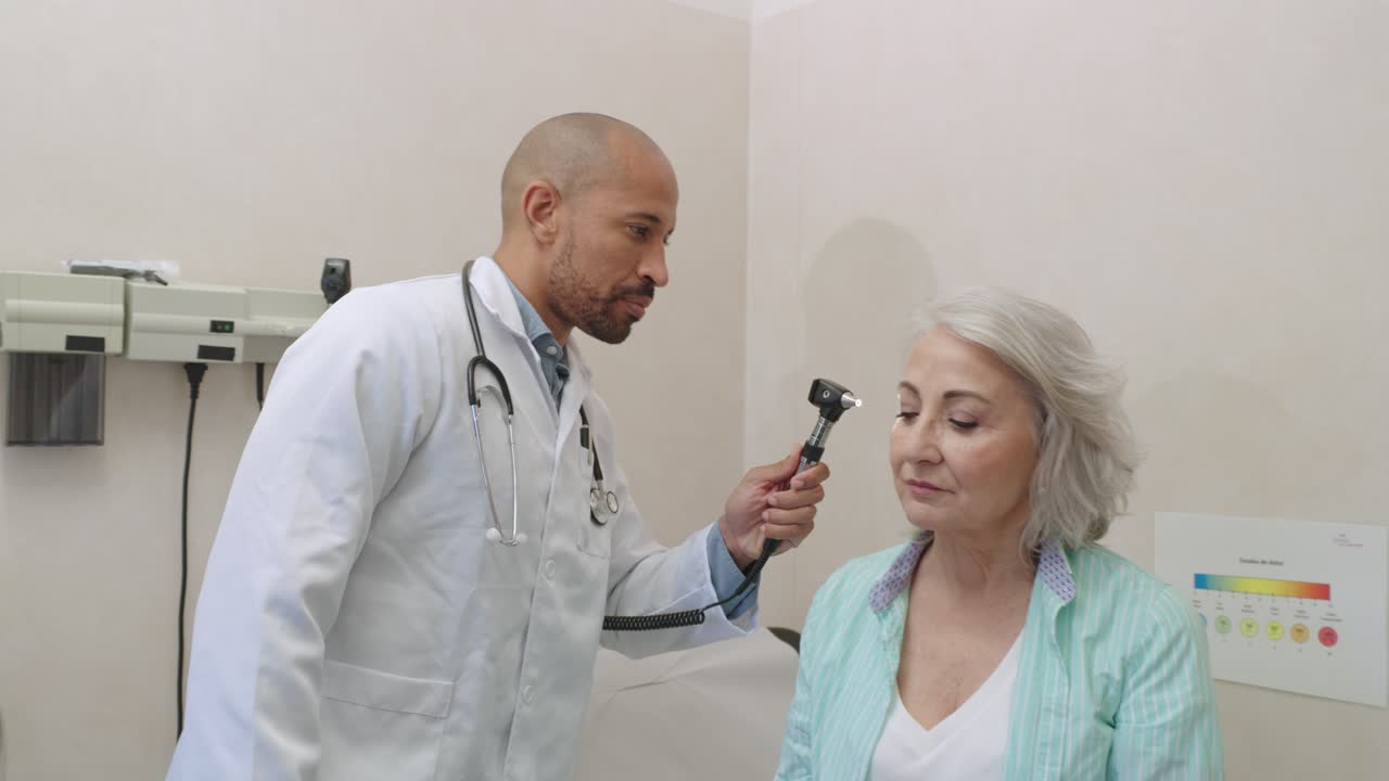 Doctor examining patient with otoscope