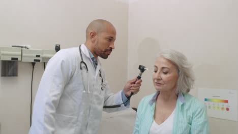 doctor examining patient with otoscope