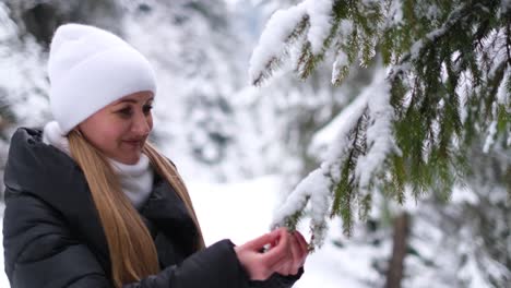 girl in a white hat in the middle of the forest looks at a green christmas tree girl in a white hat in the middle of the forest looks at a green christmas tree preholiday mood tree in fluffy white snow