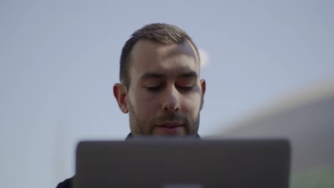 hombre guapo concentrado trabajando con una computadora portátil