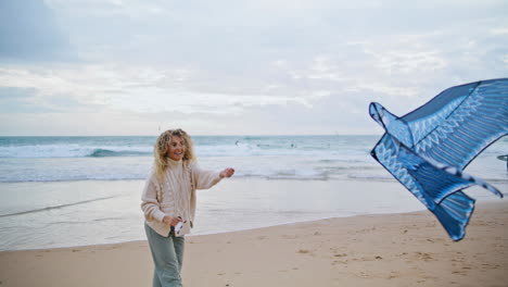 happy woman holding kite string on beach. carefree mother enjoying weekend