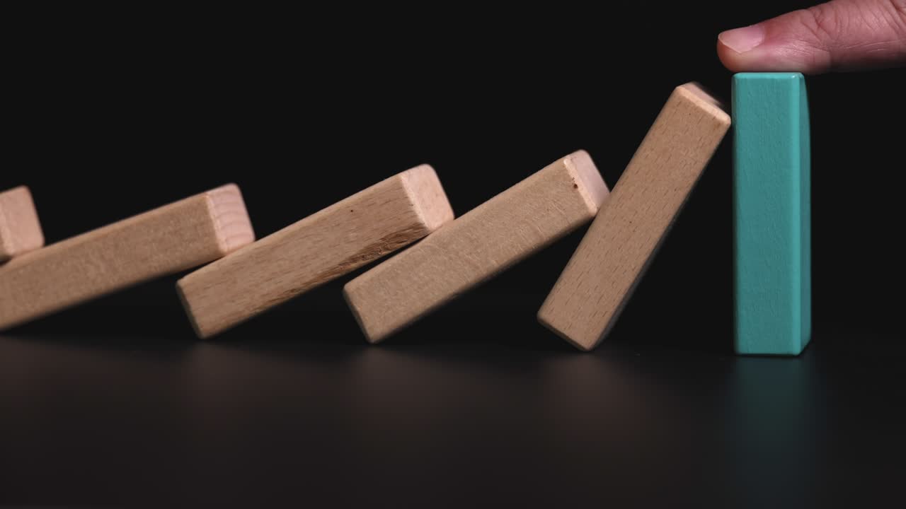 4K Video slow motion close up hand stop domino effect.