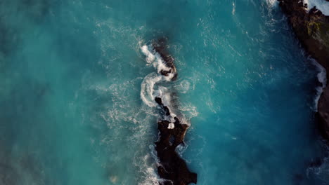 aerial-view-of-ocean-waves-breaking-on-rocks-beautiful-blue-sea-splashing-on-shoreline-coastal-surf-4k