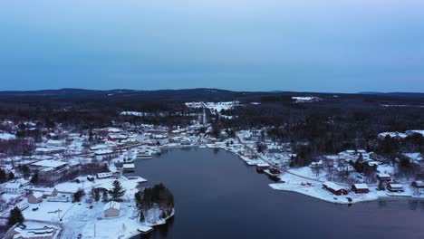 aerial footage flying high over moosehead lake towards a snow covered downtown greenville maine