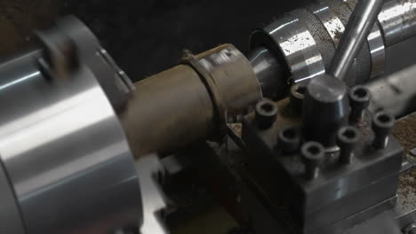 closeup of wood lathe machine boring hole into cylindrical workpiece at workshop. slow motion, zoom-in shot