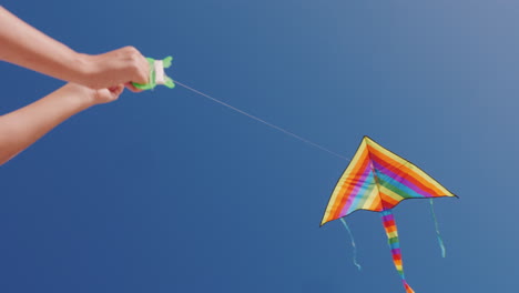 Man-Controls-Kite-That-Hovers-In-Blue-Cloudless-Sky-Low-Angle-Shot