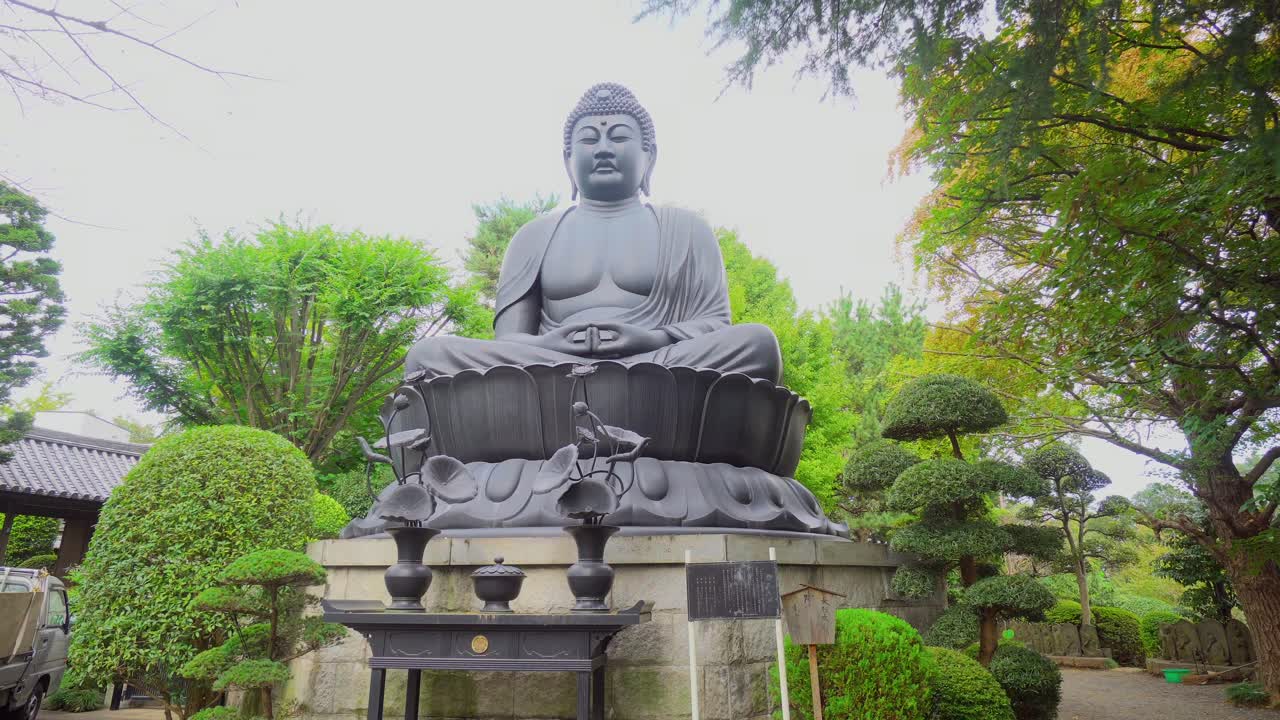 Huge Buddha statue in a remote neighborhood of Tokyo. Slow motion
