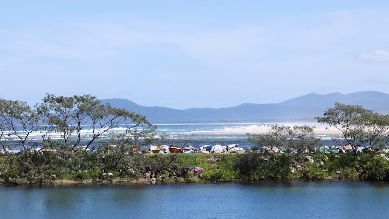 Tranquil view of river, beach, and distant mountains