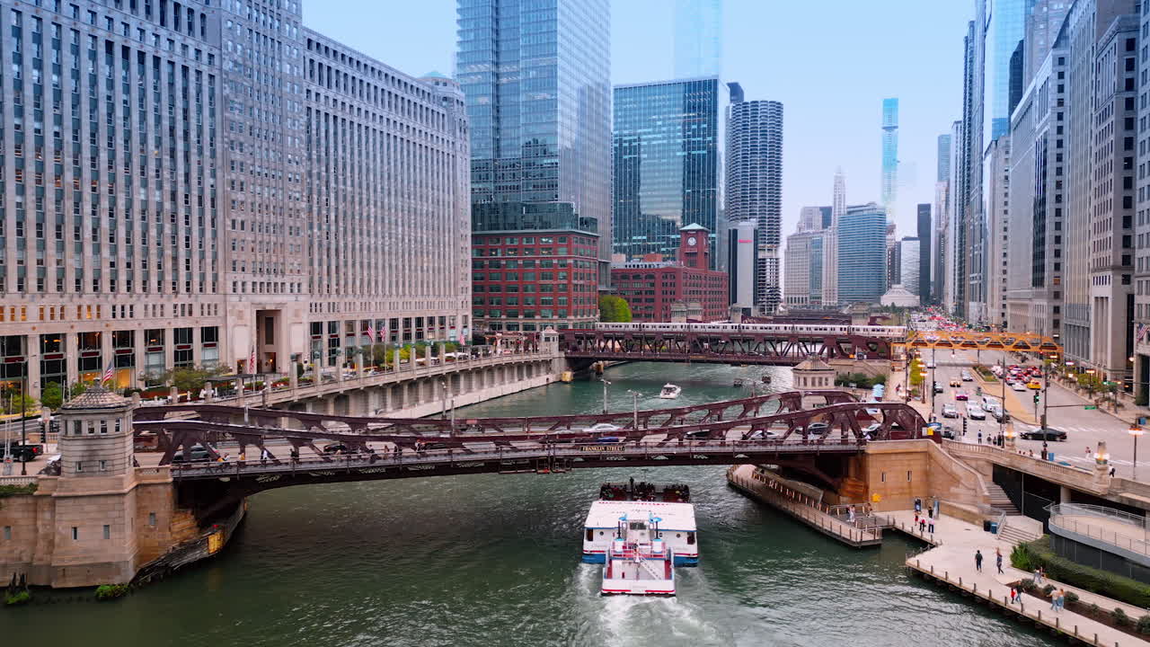 Chicago, USA, 29 June 2025: Large cruise boat goes under the bridge across the Chicago River. Train moves by the next bridge at backdrop