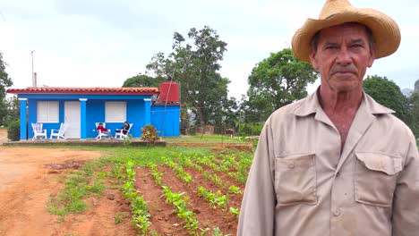un agricultor cubano se encuentra frente a una casa de campo en una granja de tabaco en viñales, cuba